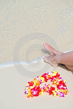 sea wave, female feet and floral Hawaiian beads