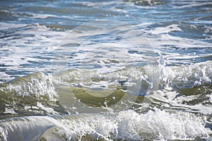 Sea wave foam on the beach in Estepona, Andalucia, Spain. Peaceful ocean waves at beach