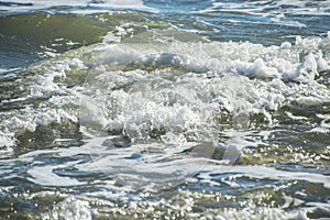 Sea wave foam on the beach in Estepona, Andalucia, Spain. Peaceful ocean waves at beach