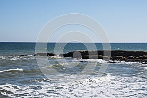 Sea wave foam and rocks on the beach in Estepona, Andalucia, Spain. Peaceful ocean waves at beach