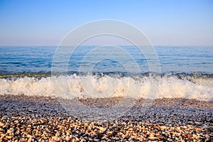 Sea wave in the morning light. Sea wave and beach. Sea wave background. Crimea. Wave and pebble beach. Rest and travel to the sea