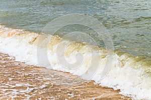 Sea wave powerfully runs onto the sandy shore