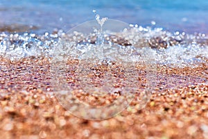 Sea wave on the sand beach, soft focus. Summer background