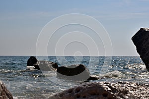 Sea wave splash on rocky beach. Ocean waves breaking on rocks.