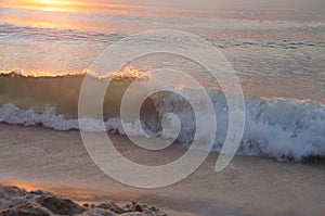 Sea wave under sunset beam