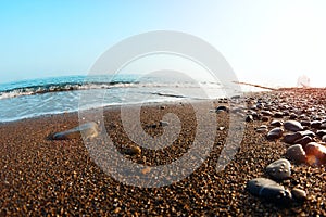 Sea waves on the beach with sunset rays