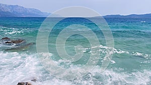 Sea waves with a beautiful landscape in the background in motion