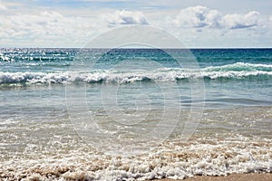 Sea waves. Blue water. White clouds