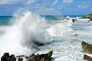 Sea waves bouncing onto rocks creating shower of water droplets