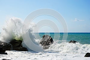 Sea waves bouncing onto rocks creating shower of water droplets