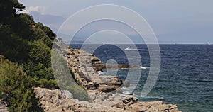 Sea waves break about the rocky coas, the cape Ferrat of South France, embankment on the azure coast, mountains and the