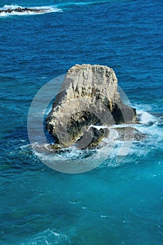 Sea waves breaking on a large rock in the water