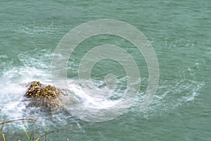 Sea waves breaking on a rocks. Deep blue sea waves hit cliff