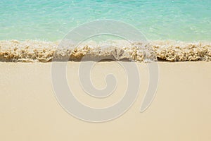 Sea waves breaking on sandy beach