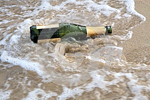 Sea waves brown sand empty champagne bottle wine glass
