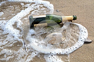 Sea waves brown sand empty champagne bottle wine glass