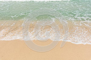 Sea waves bubbles on the sandy beach