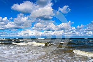 Sea waves and clouds on a blue sky