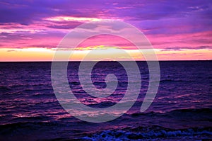 Sea waves during a colorful sunset over a romantic beach