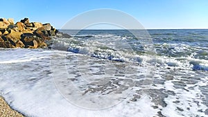 Sea waves crashing against an empty sand beach, slow motion.