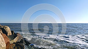 Sea waves crashing against an empty sand beach, slow motion 4K.