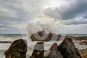 Sea waves crashing hard against a rock in winter