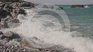 Sea waves crashing on rocks on an empty beach