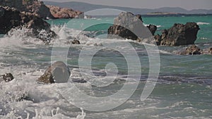 Sea waves crashing on rocks on an empty beach