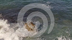 Sea waves crashing on rocks on an empty beach