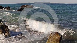 Sea waves crashing on rocks on an empty beach