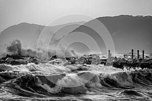 Sea waves crashing on a rocky pier in Marina di Massa