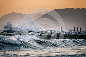 Sea waves crashing on a rocky pier in Marina di Massa