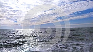 Sea waves crashing slow motion. Beautiful blue and white clody sky. Looping ocean surface texture.