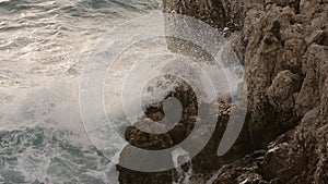 sea waves crushing over rocks with soft light