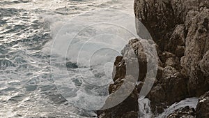 sea waves crushing over rocks with soft light