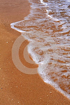Sea waves foam on the beach