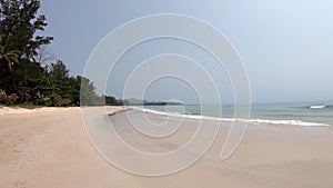 Sea waves that hit the beach  and tourists in the sea Background tree and  mountain at Thung Wua Laen Beach  , Chumphon , Thailand