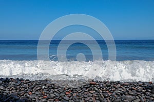Sea waves hitting the stony coast. Waves turn into sea foam. Frothy sea water and bubbles. The Azores kill water. Background