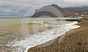 Sea waves lapping on a deserted beach in bad weather.