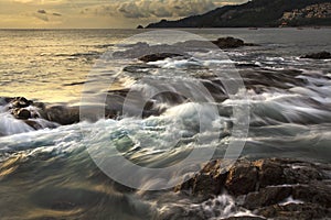 Sea waves lash line impact rock on the beach