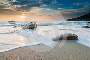 Sea waves lash line impact rock on the beach