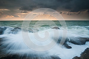 Sea waves lash line impact rock on the beach