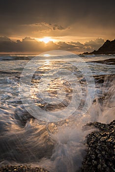 Sea waves lash line impact rock on the beach