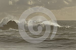 Sea waves over rocks at sunset