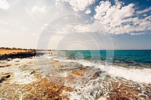 Sea waves and rocks at sunset, creamy water and clear skies on a beautiful summer day