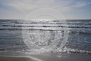 Sea, waves and sand on the beach of Paso Oscuro in Lazio in Italy photo