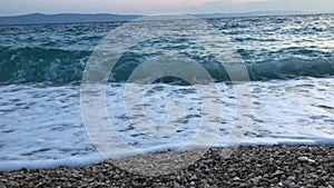 Sea waves during a storm run on the beach of the sea coast on a sunny day. Sea waves with white