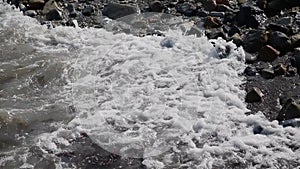 Sea waves swim ashore on a sunny day.