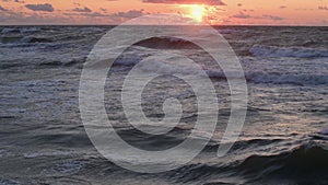 Sea waves under a dramatic sky during a storm at sunset. Surreal landscape at dusk