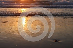 Sea waves and warm sunset light, calm and relaxing sandy beach